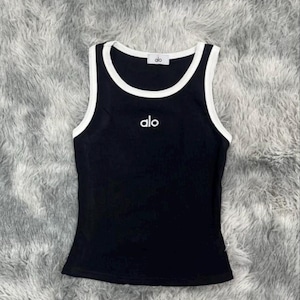 Może przedstawiać: Biały ceramiczny kubek z czarnym uchem i napisem "But First, Coffee" w stylu odręcznym. Kubek stoi na białej powierzchni. Kubek ma około 10 cm wysokości.