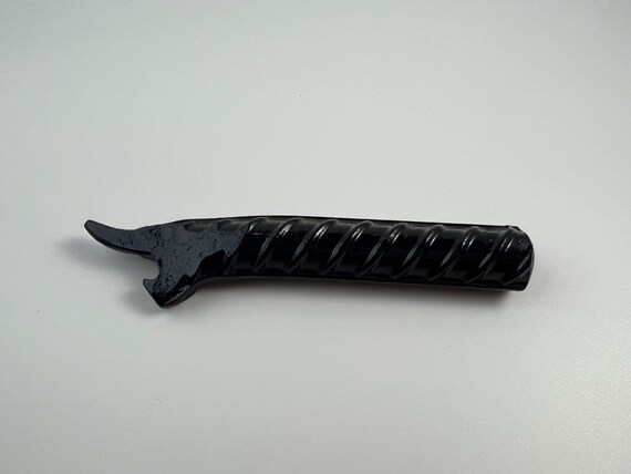 Hand-forged blacksmithing with swirling decorative details — a bottle opener that looks like a blacksmith actually sweated over it, not a factory stamped it.