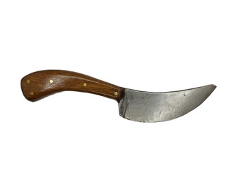 May include: A curved, hand-forged knife with a wooden handle. The handle is brown with brass accents. The blade is made of steel and has a slight curve.
