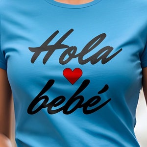 May include: A light blue t-shirt with a black graphic that says "Hola bebé" with a red heart.