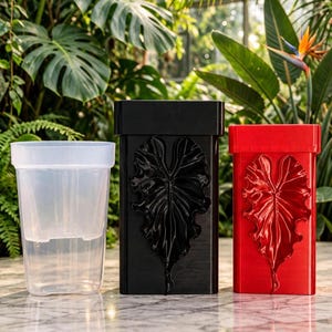May include: Three rectangular plant pots are displayed side by side. One is a clear, translucent plastic inner liner. The second is a solid black outer pot with a raised, textured leaf design on the front. The third is a solid red outer pot with an identical raised leaf design.
