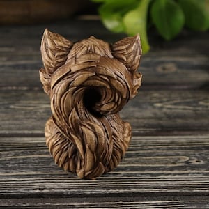 Pu&ograve; includere: Una scultura in legno di una volpe con la coda arrotolata attorno al suo corpo. La scultura &egrave; dettagliata e realistica, con una finitura in legno marrone.