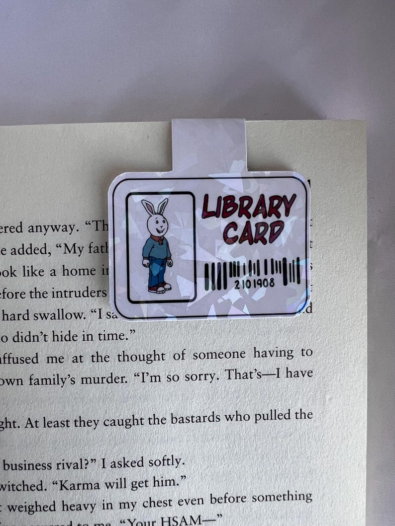 Puede incluir: Un marcap&aacute;ginas blanco con un conejito de dibujos animados y el texto "LIBRARY CARD" con un c&oacute;digo de barras que dice "2101908".