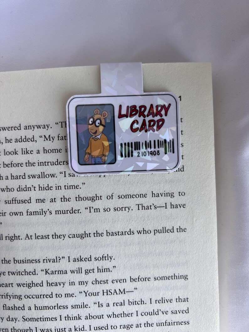 Puede incluir: Un personaje de dibujos animados con gafas y una camisa marr&oacute;n sostiene una tarjeta de biblioteca con el texto "LIBRARY CARD" y el n&uacute;mero "2101908".