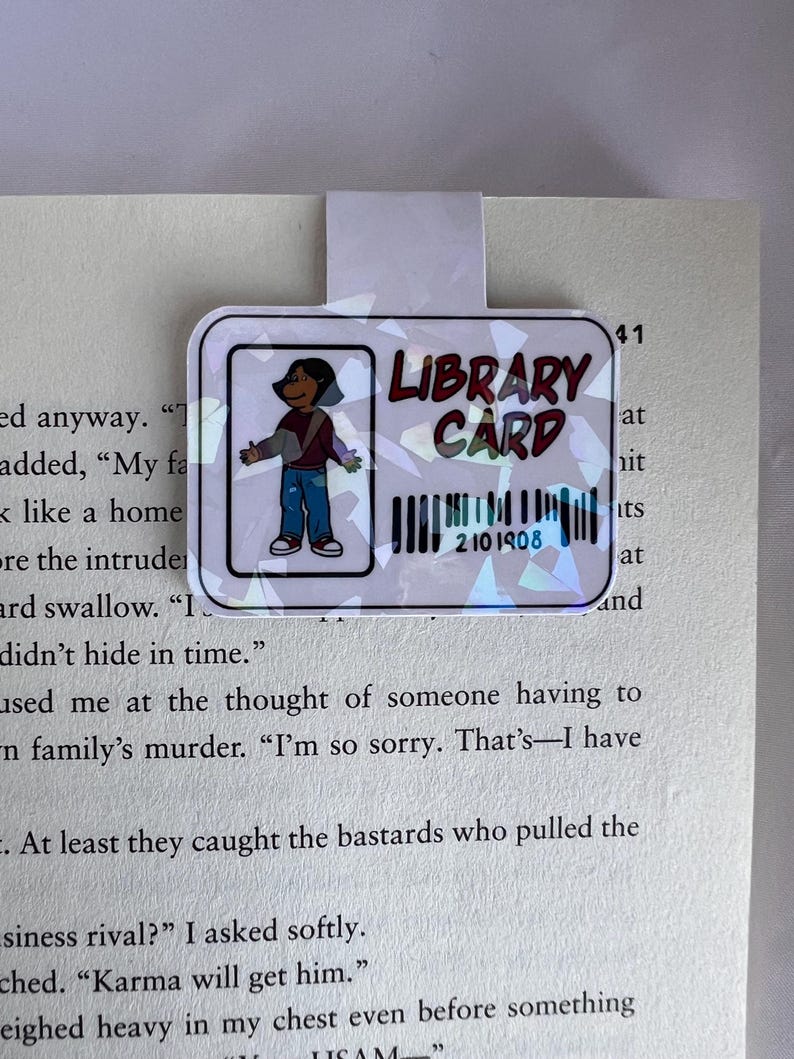 Puede incluir: Una tarjeta de biblioteca colorida con una ilustraci&oacute;n de dibujos animados de una persona. La tarjeta tiene el texto "LIBRARY CARD" y un c&oacute;digo de barras con el n&uacute;mero "2101908".