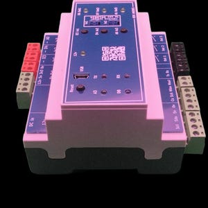 May include: A pink and blue electronic circuit board with various ports, connectors, and a USB port. The board has text and a QR code printed on it. The device has red, black, and green connectors on the sides.