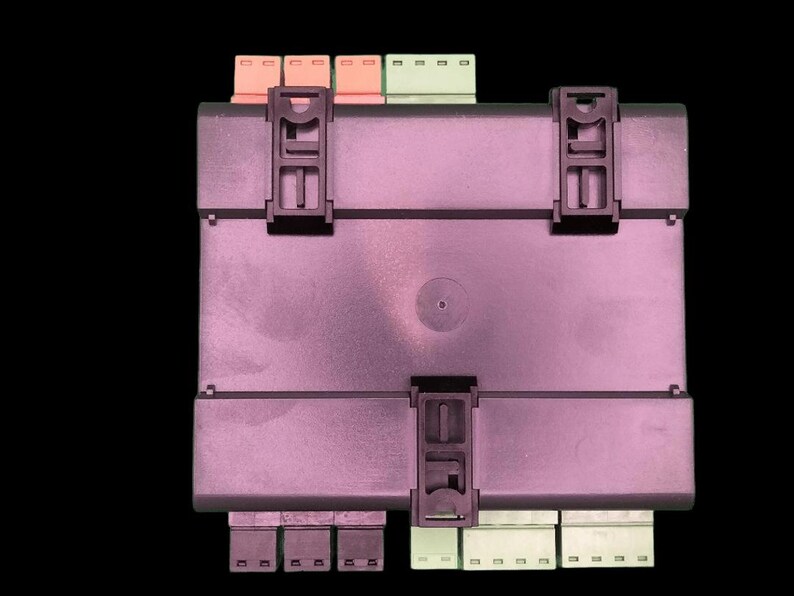 May include: A rectangular, dark purple electronic component with black clips and connectors. The component has several coloured connectors, including orange, green, and white, and is set against a black background.