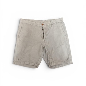 May include: Light beige shorts with a textured pattern. The shorts feature a button and zip closure, and front pockets. The garment is made of a lightweight fabric, suitable for warm weather.