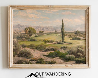 May include: A framed oil painting depicting a golf course in a desert landscape. The painting features a green golf course with a sand trap, a tall cypress tree, and a distant mountain range. The sky is a light blue with white clouds.