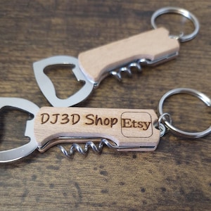 Op de afbeelding: Drie houten flesopener sleutelhangers met een kurkentrekker en flesopener. De tekst "DJ3D Shop Etsy" is gegraveerd op een sleutelhanger. De sleutelhangers hebben een zilveren metalen flesopener en sleutelring.