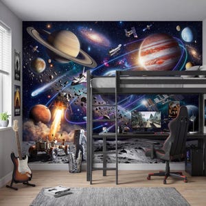 Può includere: Una stanza con un murale a tema spaziale raffigurante pianeti, galassie e un lancio di razzi. Un letto a soppalco nero con una scrivania e una sedia da gioco è allestito di fronte al murale. Sono visibili una chitarra e dei poster.