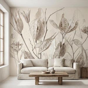 Pode incluir: Um mural botânico em tons sépia com ilustrações detalhadas de vagens de sementes e folhas. A obra de arte é montada em uma parede acima de um sofá de cor neutra, com uma mesa de centro e uma mesa lateral de madeira na frente.