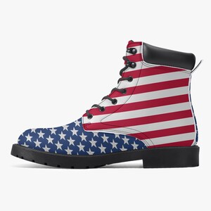 May include: A combat boot featuring the American flag design. The boot has a black sole and heel, with the upper portion displaying the stars and stripes of the U.S. flag. The boot has black laces and a black leather collar.