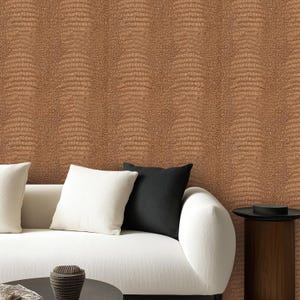 May include: A living room scene featuring a white sofa with white and black throw pillows. The wall behind the sofa is covered in brown textured wallpaper, resembling crocodile skin. A small wooden side table is next to the sofa.