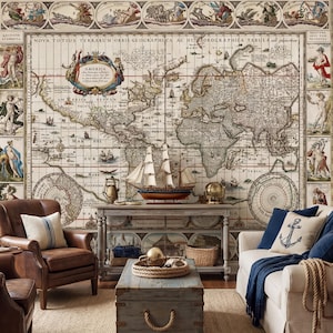 Könnte beinhalten: Ein Wohnzimmer mit einer Tapete mit einer Vintage-Weltkarte. Ein brauner Ledersessel und ein weißes Sofa mit blauen Kissen und einer Decke. Ein Holzschiffsmodell und ein blauer Truhentisch vervollständigen das nautische Thema.