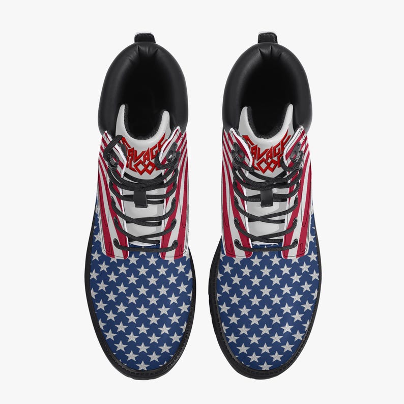 May include: Pair of black-soled boots featuring a patriotic design. The upper part of the boots displays the American flag with red and white stripes, while the lower part showcases a blue field with white stars. The boots have black laces and a black collar.