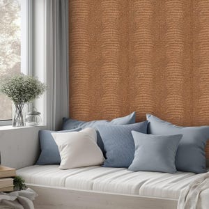 May include: A cozy window seat with a collection of pillows in shades of blue and white. The wall is covered in a textured, brown wallpaper. A vase of flowers sits on the windowsill, adding a touch of nature to the scene.