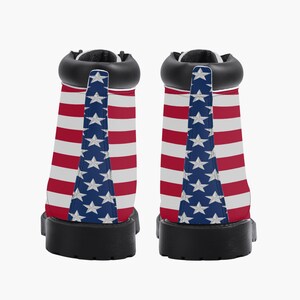 May include: Pair of ankle boots featuring the American flag design. The boots have a black collar, sole, and heel. The sides of the boots display red and white stripes, with a blue panel featuring white stars.