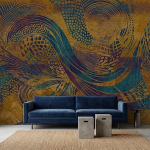 May include: A living room scene featuring a navy blue sofa, two concrete side tables, and a woven rug. The wall is adorned with a large, abstract mural in shades of gold, teal, and purple, creating a modern and artistic ambiance.