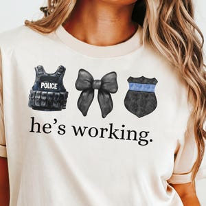 Ele está trabalhando PNG, esposa policial, esposa policial, policial, presentes para esposas de policiais, punhos de arco de distintivo de polícia de linha azul fina LEOW Coquette