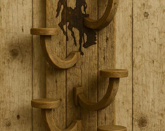 May include: Wooden wall-mounted shelf with a rustic cowboy theme. The shelf features a silhouette of a cowboy on a horse, with five curved shelves for display. The background is made of wooden planks.