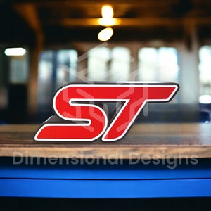 May include: A red and black 3D printed "ST" logo. The logo is on a wooden surface.