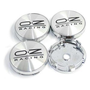 Puede incluir: Juego de cuatro tapacubos OZ Racing de color plateado. Cada tapón presenta el logotipo OZ Racing en negro. Un tapón está desmontado, mostrando el mecanismo interno. Los tapones son redondos y tienen un acabado brillante.
