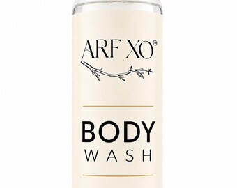 May include: A clear plastic bottle of body wash with a black cap and a cream-colored label. The label features the text ARF XO, a line drawing of a branch, the words BODY WASH, the phrase Have buttery soft glowing skin, and 8 oz.