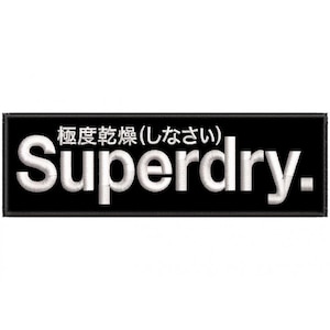 Op de afbeelding: Een zwart rechthoekig embleem met witte geborduurde tekst. De tekst luidt "Superdry" in een vetgedrukte letter, met Japanse karakters erboven. Het embleem heeft een gestikte rand.