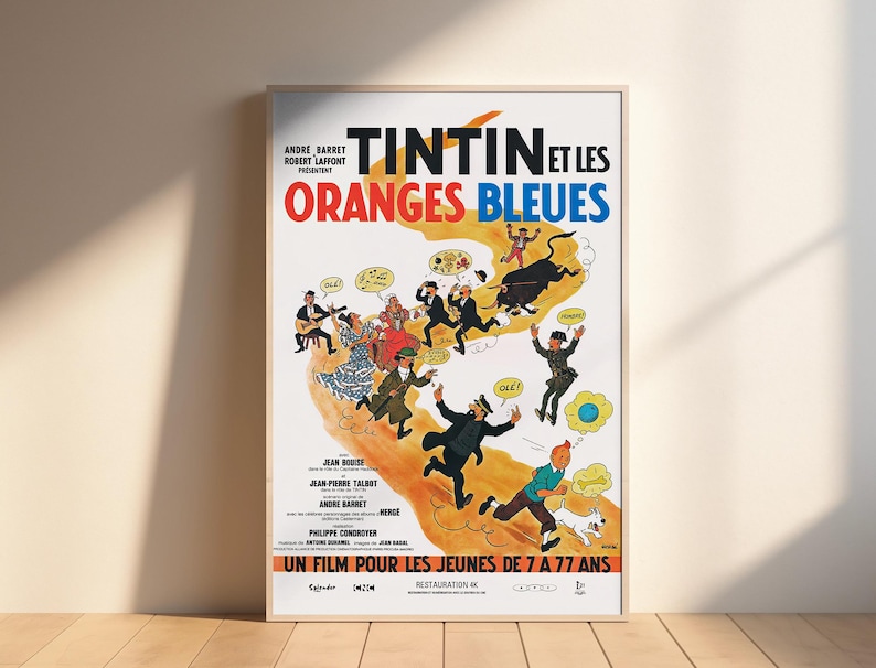 May include: A vintage movie poster for the animated film "Tintin et les Oranges Bleues". The poster features a colorful illustration of Tintin and his friends, including Captain Haddock, Snowy, and the Thompson Twins. The poster is set against a white background with a blue and orange color scheme. The text on the poster reads "Tintin et les Oranges Bleues" and "Un film pour les jeunes de 7 a 77 ans".