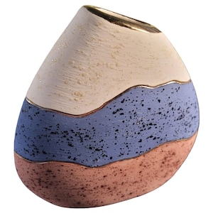 May include: A decorative ceramic vase with a unique, layered design. The top section is off-white with a textured finish, followed by a blue speckled band, and a bottom section in a reddish-brown hue. Gold trim accents the top and the borders between the colors.