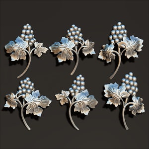Könnte beinhalten: Sechs silberfarbene Metall-Weinreben-Ornamente mit Blättern und Trauben. Die Ornamente sind detailliert und haben ein realistisches Aussehen.