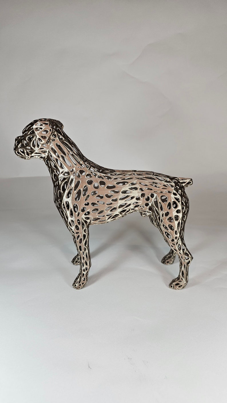 May include: A silver-colored metal sculpture of a boxer dog. The sculpture is made of a wire mesh design, creating a detailed and intricate look.