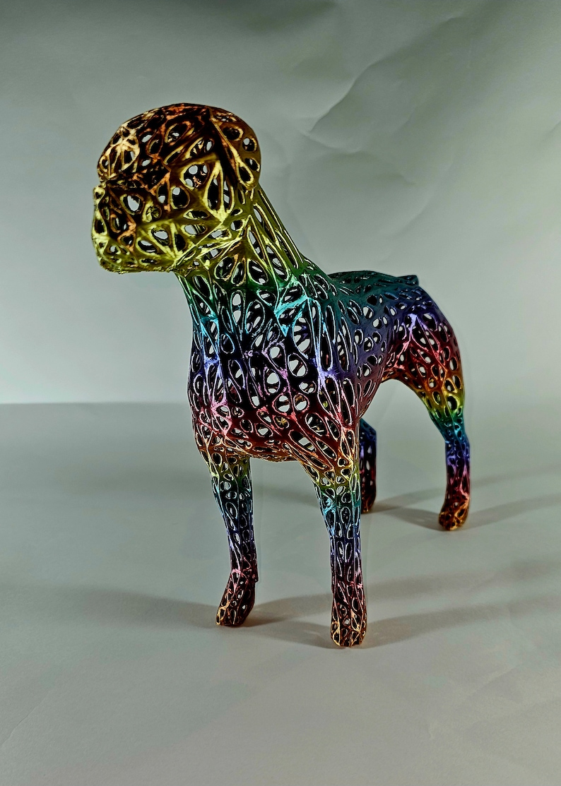 May include: A rainbow-colored, 3D printed dog sculpture with a wireframe design. The sculpture is made of a translucent material and has a metallic finish.