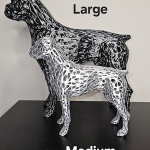 May include: Two wireframe dog sculptures, one large and one medium, in black and silver finishes. The sculptures are posed in a standing position. The text "Large" and "Medium" are printed below the sculptures.