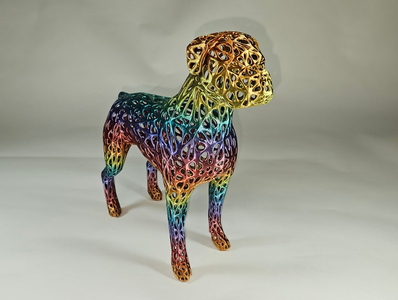 May include: A rainbow-colored, 3D printed dog sculpture. The dog is standing on all four legs and has a detailed, intricate design.