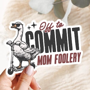 May include: A sticker featuring a goose wearing sunglasses and riding a scooter. The text on the sticker reads "Off to COMMIT MOM FOOLERY" in a playful font, with a star graphic.
