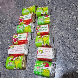 Peut inclure: Une collection de barres chocolatées emballées individuellement avec un emballage sur le thème des fêtes. Les emballages présentent le personnage du Grinch dans diverses poses, ainsi que le texte "Merry Grinchmas" et "Holiday Whobilation".