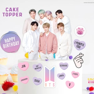 Puede incluir: Un topper para pastel con un grupo de siete hombres vestidos de blanco y rosa, con el texto "CAKE TOPPER" y "HAPPY BIRTHDAY" en morado y rosa. El topper también incluye un corazón morado con el texto "I PURPLE YOU" y un corazón rosa con el text "V".
