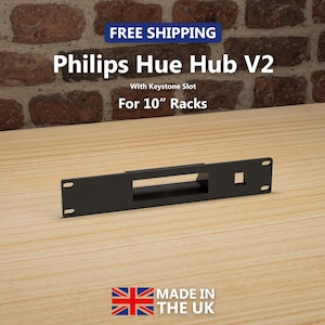 May include: A black Philips Hue Hub V2 rack mount with a keystone slot, designed for 25.4 cm racks. The text "FREE SHIPPING" is displayed at the top. The product is made in the UK.