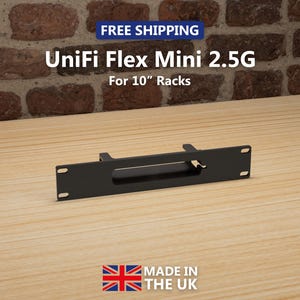 以下が含まれることがあります： 10インチラック用の黒いUniFi Flex Mini 2.5Gラックマウント。この製品は英国製です。画像は、レンガの壁を背景に、木製の表面に置かれた製品を示しています。「FREE SHIPPING」の文字が上部に表示されています。