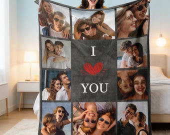 May include: A personalized photo blanket featuring a collage of images. The blanket has a dark gray background with the words "I LOVE YOU" and a red heart in the center. The blanket is being held up by a smiling person.