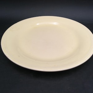 May include: A cream-coloured, oval-shaped plate with a slightly raised rim. The plate has a smooth surface and a simple, classic design. This dish is suitable for serving food.