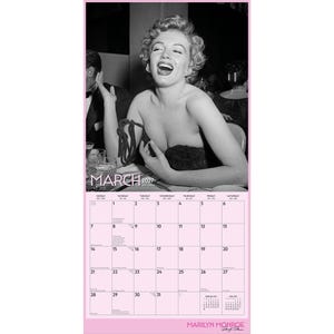 K&ouml;nnte beinhalten: Ein Wandkalender f&uuml;r M&auml;rz 2027 mit einem schwarz-wei&szlig;en Foto von Marilyn Monroe, die lacht. Das Kalenderraster ist auf einem hellrosa Hintergrund gedruckt, mit dem Text MARCH 2027 oben und MARILYN MONROE unten.