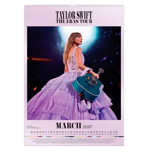 Puede incluir: Un calendario de pared para marzo de 2027 con Taylor Swift The Eras Tour. La imagen muestra a una persona con un vestido lavanda de varias capas sosteniendo una guitarra ac&uacute;stica azul verdoso en el escenario. Incluye mes, a&ntilde;o y calendario.