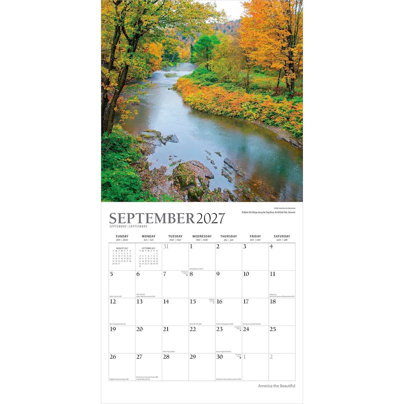 Peut inclure: Un calendrier mural pour septembre 2027 pr&eacute;sentant une photographie d'une rivi&egrave;re coulant &agrave; travers une for&ecirc;t avec un feuillage d'automne dans des tons orange, jaune et vert. La grille du calendrier affiche les jours avec du texte noir sur fond blanc.