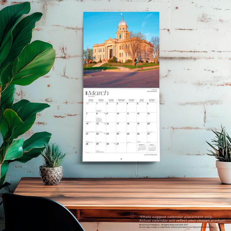 May include: A wall calendar for March 2027 featuring a photograph of a large, light-colored stone building with a central dome and columns. The calendar grid below the image displays the days of the month with black text on a white background.