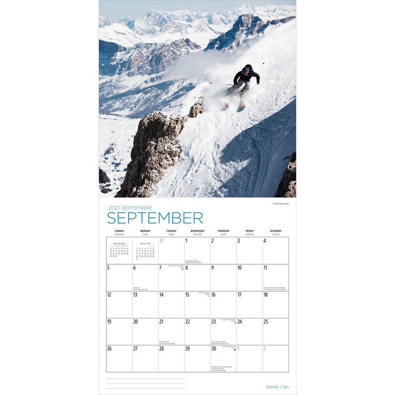Op de afbeelding: Een wandkalender voor september 2027 met een foto van een ski&euml;r die een steile, met sneeuw bedekte berghelling afdaalt. Het kalenderraster toont de dagen van de maand met duidelijke zwarte tekst op een witte achtergrond.