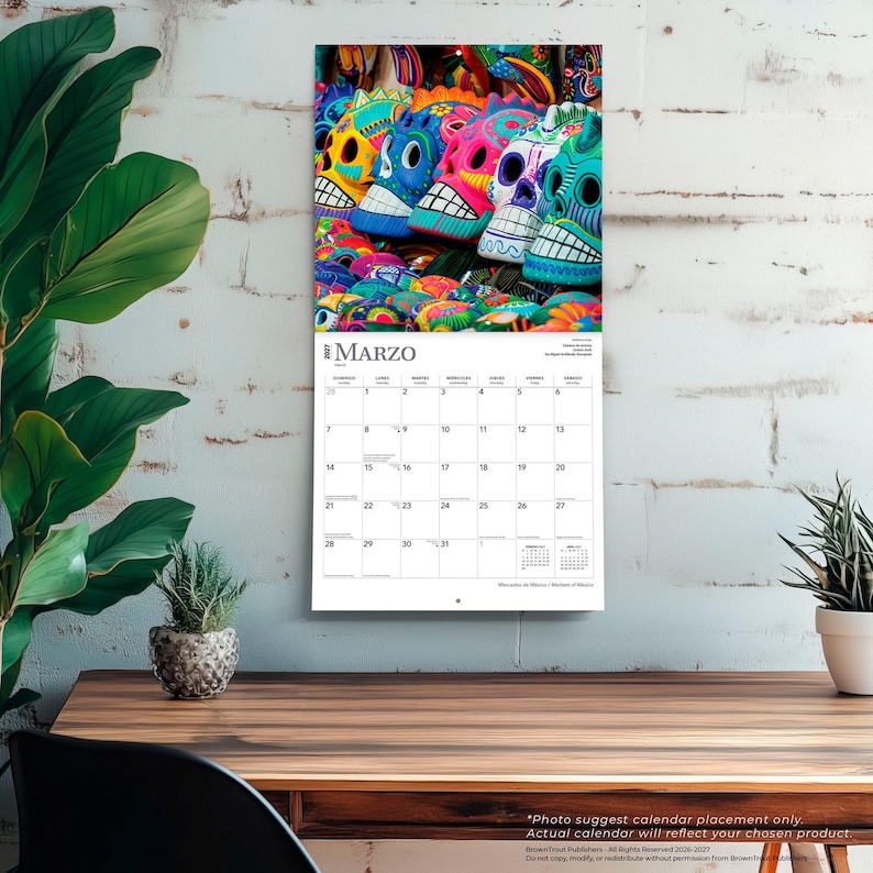 Puede incluir: Un calendario de pared para el mes de marzo de 2027 que presenta una fotograf&iacute;a de coloridas calaveras de az&uacute;car decorativas. La cuadr&iacute;cula del calendario muestra los d&iacute;as de la semana en espa&ntilde;ol, con el t&iacute;tulo MARZO impreso en la parte superior.
