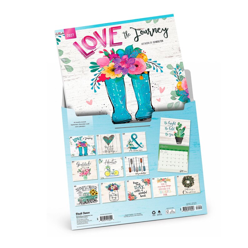 May include: A 2027 wall calendar titled Love the Journey with artwork by Jo Moulton. The cover features bright teal rain boots filled with colourful flowers. The back displays twelve monthly grid pages with various floral and seasonal illustrations.